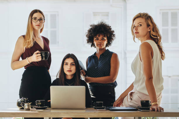 istockphoto-1039076422-612x612 Group of multiracial businesswomen in casuals together at office desk and looking at camera. Female startup business team portrait.